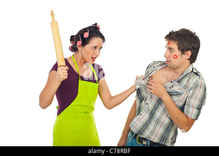 Furious casalinga battere il marito infedele con una spina isolata di rotolamento su sfondo bianco Foto Stock