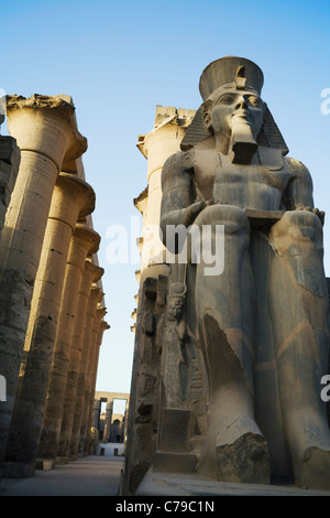 Seduto colossale statua di Ramses II e Colonnato di Amenofi III al Tempio di Luxor, Luxor, Egitto Foto Stock