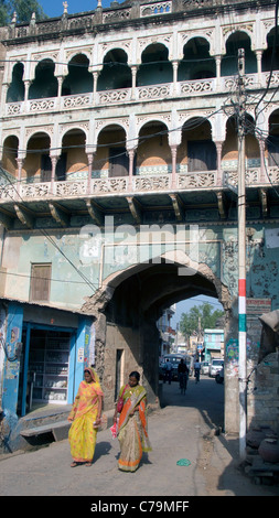 Due donne a piedi attraverso haveli mansion style arch Mandawa Rajasthan in India Foto Stock