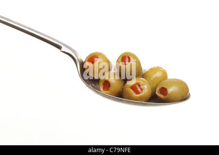 Il pimento Olive farcite in un cucchiaio d'argento isolato contro bianco Foto Stock