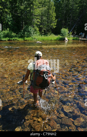 Donna escursionista attraversa il Popo Agie nel fiume del Wyoming Wind River gamma Foto Stock