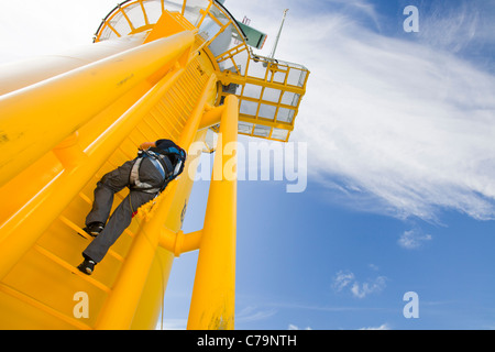 Un operaio si arrampica su una turbina, al Walney offshore wind farm che consiste di 102, 3,6 MW. Foto Stock