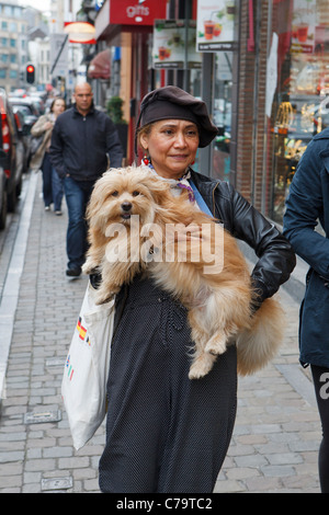 La donna che porta il cane Foto Stock