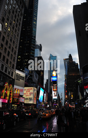 Il crepuscolo ritratto asfalto bagnato dalla pioggia riflessioni traffico grattacieli al neon persone, 7th Avenue, Times Square a New York City Foto Stock