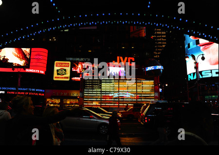 Night Shot luci blu Hard Rock Cafe marquee, guardando verso luci al neon colorate JVC cartelloni, 7th Avenue, Times Square, New York Foto Stock