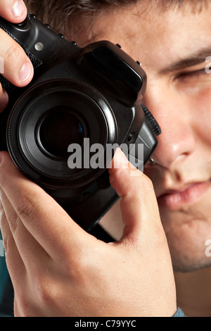 Un giovane fotografo adolescente di scattare una foto con la sua fotocamera reflex digitale. Profondità di campo. Foto Stock