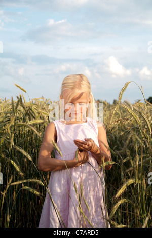 Ragazza 6 anni, indossando un abito in un campo di grano in estate, Eyendorf, Bassa Sassonia, Germania, Europa Foto Stock