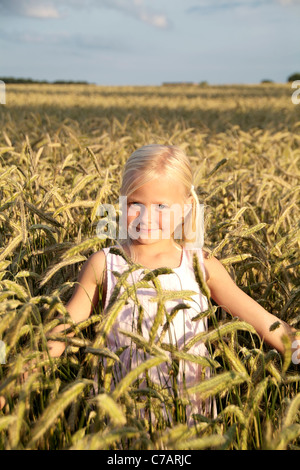 Ragazza 6 anni, indossando un abito in un campo di grano in estate, Eyendorf, Bassa Sassonia, Germania, Europa Foto Stock