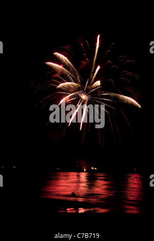 Bellissimi fuochi d'artificio di andare oltre il cielo notturno riflettendo sull'acqua. Foto Stock
