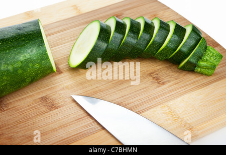 Le fette di zucchine su un tagliere di legno Foto Stock