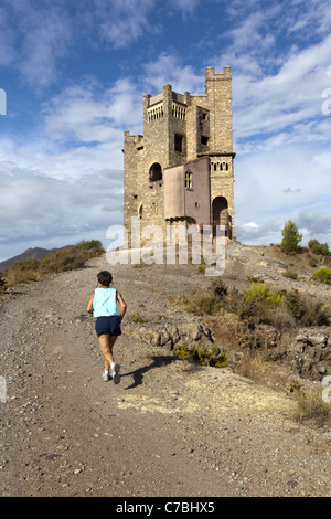 Runner vicino alla torre d'acqua a La Mota edificio abbandonato lo sviluppo, appena fuori a Alhaurin El Grande, Andalusia Foto Stock