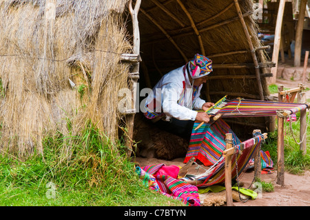 Il quechua donna indiana si intreccia con una fascetta telaio in Cusco, Perù Foto Stock