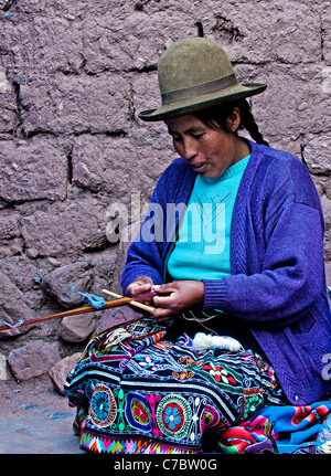 Il quechua donna indiana si intreccia con una fascetta telaio in Cusco, Perù Foto Stock