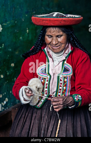 Il quechua donna indiana si intreccia con una fascetta telaio in Cusco, Perù Foto Stock