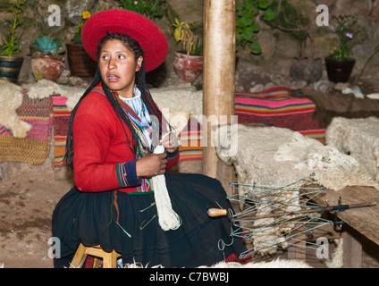 Il quechua donna indiana si intreccia con una fascetta telaio in Cusco, Perù Foto Stock