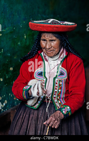 Il quechua donna indiana si intreccia con una fascetta telaio in Cusco, Perù Foto Stock