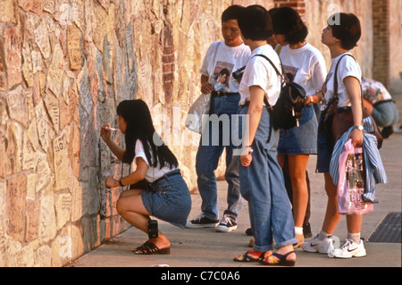 Elvis Presley fan provenienti da Hong Kong scrivere messaggi sul muro di pietra intorno a Graceland per l anniversario Foto Stock