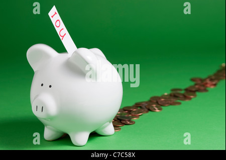 Gruppo di suini con IOU che esce di slot di monete e monetine proveniente dalla parte posteriore Foto Stock