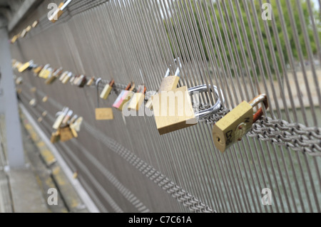 Lucchetti apposta per la scherma su un ponte pedonale a Parigi, Francia. Foto Stock