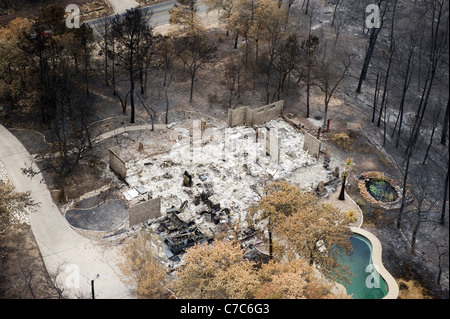 Mostra antenna wildfire danni alla foresta e una casa distrutta in una suddivisione di Bastrop County, Texas Foto Stock