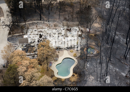 Mostra antenna wildfire danni alla foresta e una casa distrutta in una suddivisione di Bastrop County, Texas Foto Stock