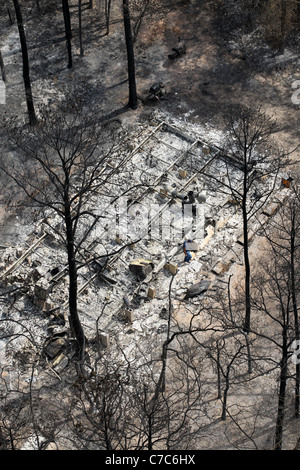 Antenna di wildfire danni nella contea di Bastrop, TX rappresenta il fondamento di bruciato home nella boscosa zona residenziale. Foto Stock