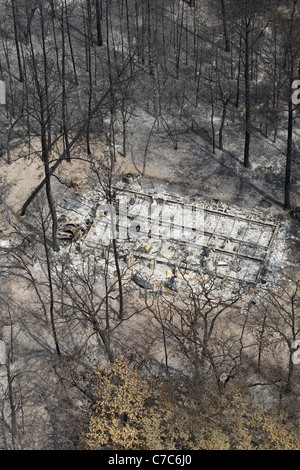 Antenna di wildfire danni nella contea di Bastrop, TX rappresenta il fondamento di bruciato home nella boscosa zona residenziale. Foto Stock