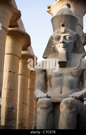 Seduto Statuto colossale di Ramses II e Colonnato di Amenofi III, Tempio di Luxor Luxor Egitto Foto Stock