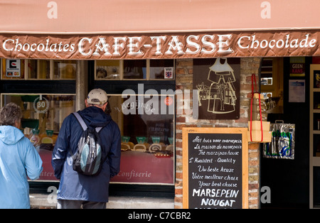 I turisti che cercano nella vetrina di un negozio di cioccolato a Bruges, Belgio Foto Stock