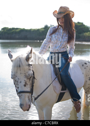 Cowgirl a cavallo sulla spiaggia Foto Stock