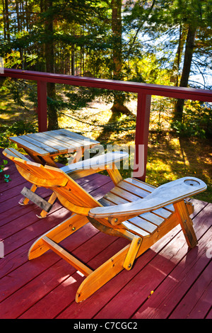 Ponte di Legno di cottage con vista lago e sedia Adirondack Foto Stock