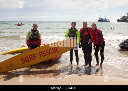Membri della RNLI surf di squadre di soccorso spiaggia di Bournemouth Inghilterra REGNO UNITO Foto Stock