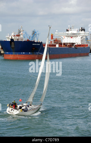 Barca a vela su Southampton acqua UKSA Libertà passando il bulk petroliera Navion Oceania ormeggiato a Fawley Terminale Marino England Regno Unito Foto Stock