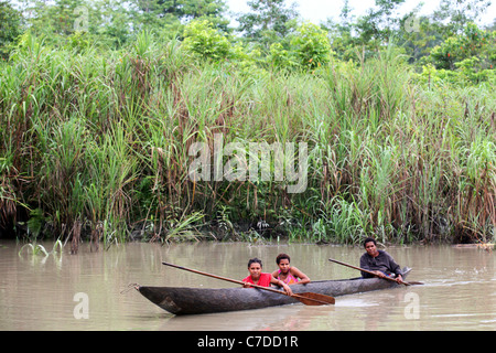 Tre ragazze in una piroga sulle rive di un fiume in Papua Nuova Guinea Foto Stock