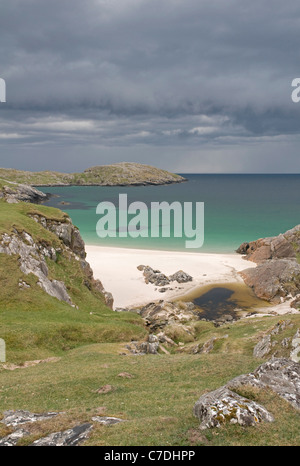 Spiaggia sabbiosa isolata a: Achmelvich Bay scure nuvole temporalesche approccio dall'orizzonte occidentale Foto Stock