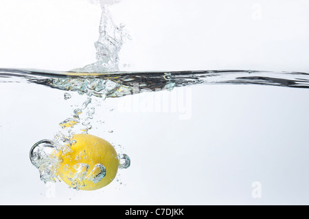 Spruzzi di limone in acqua Foto Stock