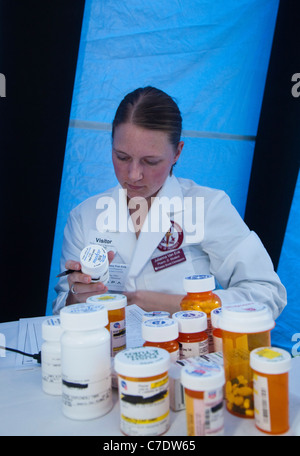 Farmacisti raccogliere indesiderate o scaduto prescrizione e over-the-counter farmaci per lo smaltimento sicuro. Foto Stock