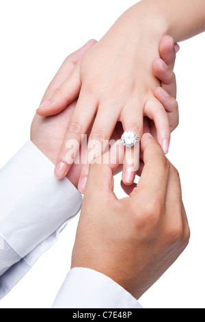 Lo sposo posizionando l'anello sul sposa Foto Stock