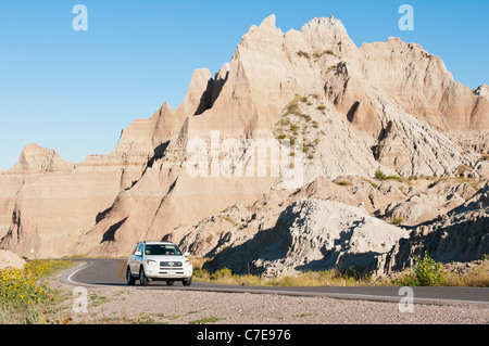 Un turista femminile in un'automobile si sposta attraverso il Parco nazionale Badlands in Sud Dakota. Foto Stock