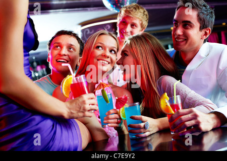 Foto di belle ragazze e ragazzi guardando uno dei loro amici seduti sulla barra Foto Stock