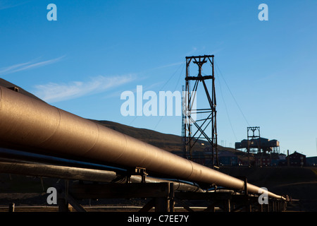 Il riscaldamento termico tubi a Longyearbyen, Svalbard. Old Coal Mining Machinery in background Foto Stock