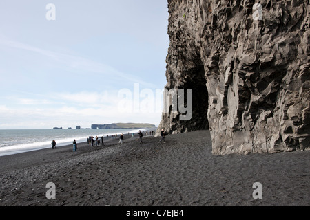 I turisti in spiaggia Reynisfjara, basalto colonnare in retro - Foto Stock