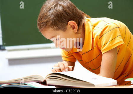 Ritratto di smart lad libro di lettura al suo posto Foto Stock