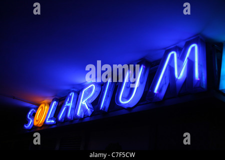 Neon blu segno solarium presso il centro di bellezza di notte Foto Stock