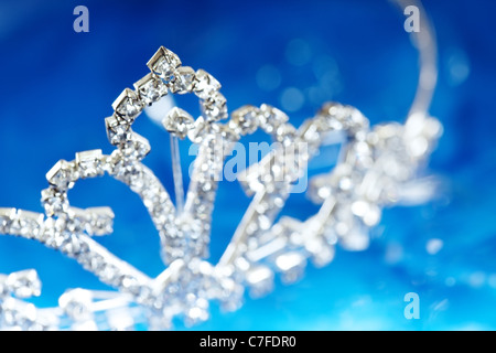 Close-up di foto il diadema di argento con diamanti su uno sfondo blu con bokeh di fondo Foto Stock