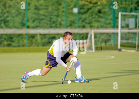 Un maschio di giocatore di hockey in azione su un astro turf pitch Foto Stock