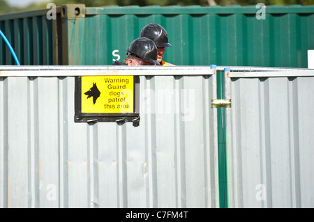 Ufficiali giudiziari guardando oltre il recinto del composto prima lo sfratto di viaggiatori di Dale Farm, Basildon, Essex. Foto:Simon Ford Foto Stock