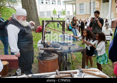 I visitatori a partecipare a blacksmithing storia vivente dimostrazione presso la riapertura della Hamilton Grange National Memorial Foto Stock