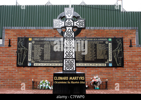 Celtic cross a clonard martiri memorial garden accanto alla linea di pace nella parte occidentale di Belfast, Irlanda del Nord Foto Stock