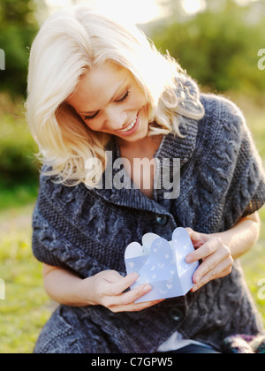 Una donna felice apertura di una confezione regalo Foto Stock